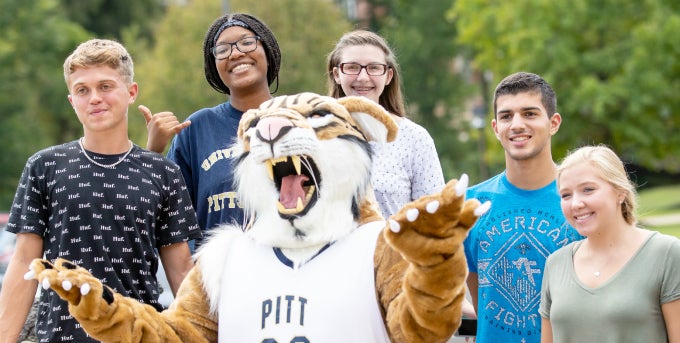 Five students posing with Bobcat mascot
