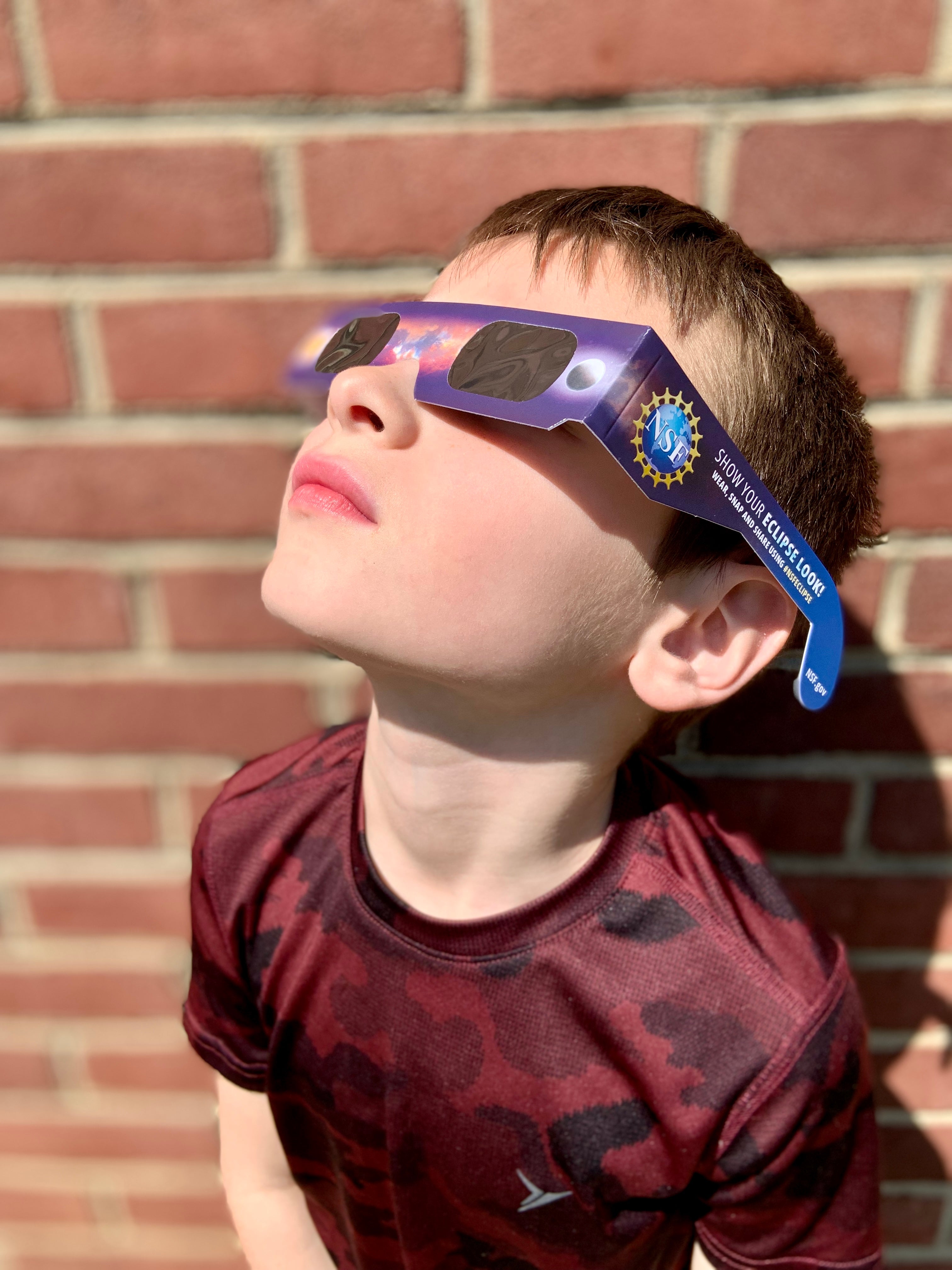 Young boy using eclipse glasses